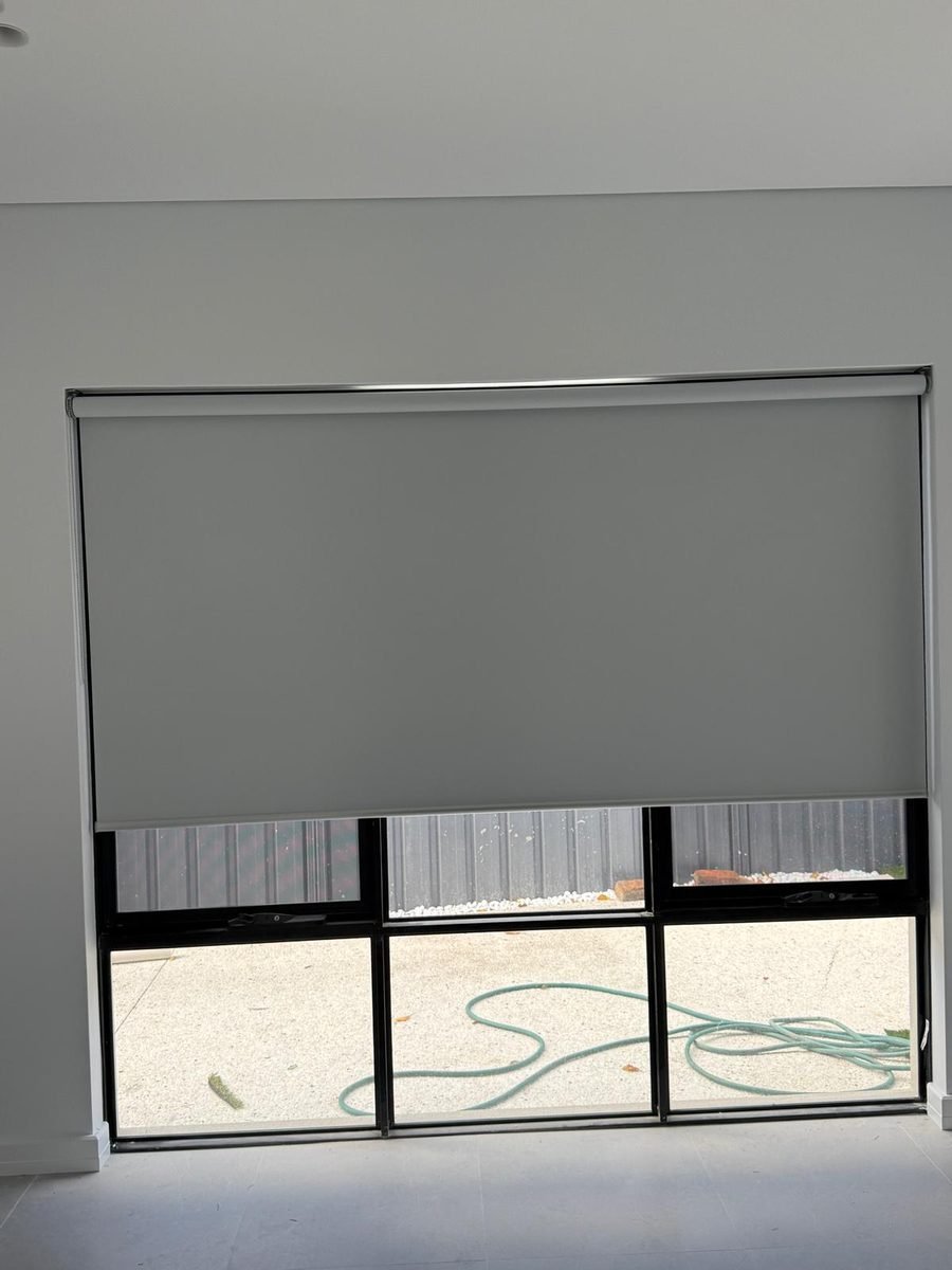 Grey roller blind fitted over a bedroom window in Perth