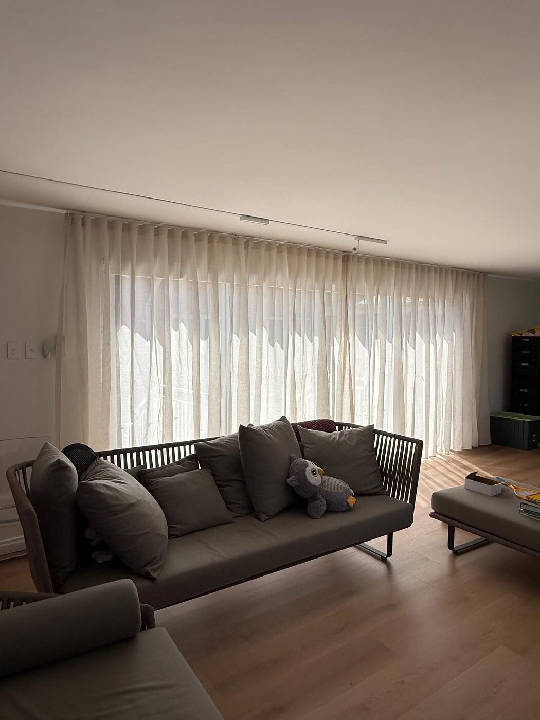 Wave-fold sheer curtains across floor-to-ceiling living room windows in a Perth home