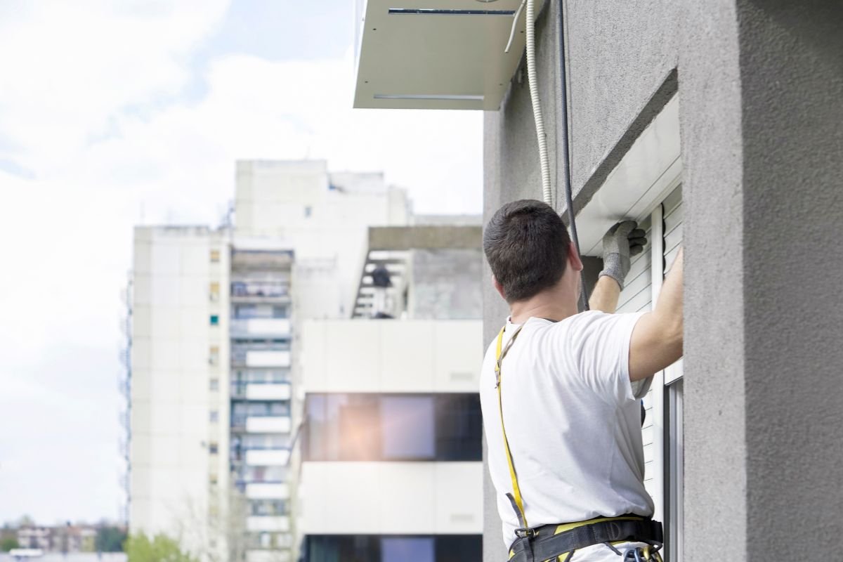 Technician repairing a roller blind mechanism in a Perth home